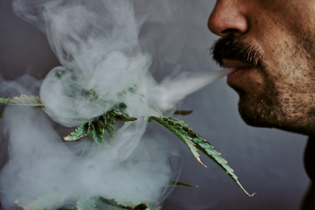 detail shot of a young man smelling smoking a blunt