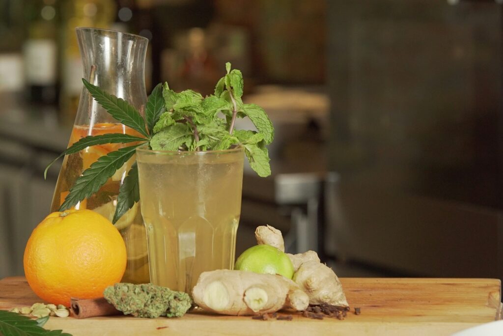 Healthy drink made of lime, ginger, and cannabis on a wooden surface