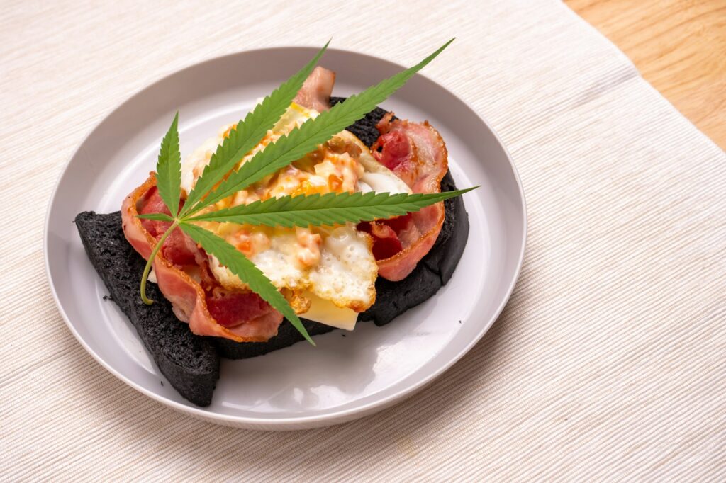 Homemade breakfast with marijuana or cannabis leaf on white plate.