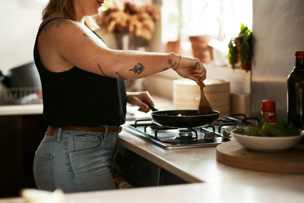 Stirring prevents sticking. Cropped shot of a woman preparing a meal at home. - Cooking with Cannabis