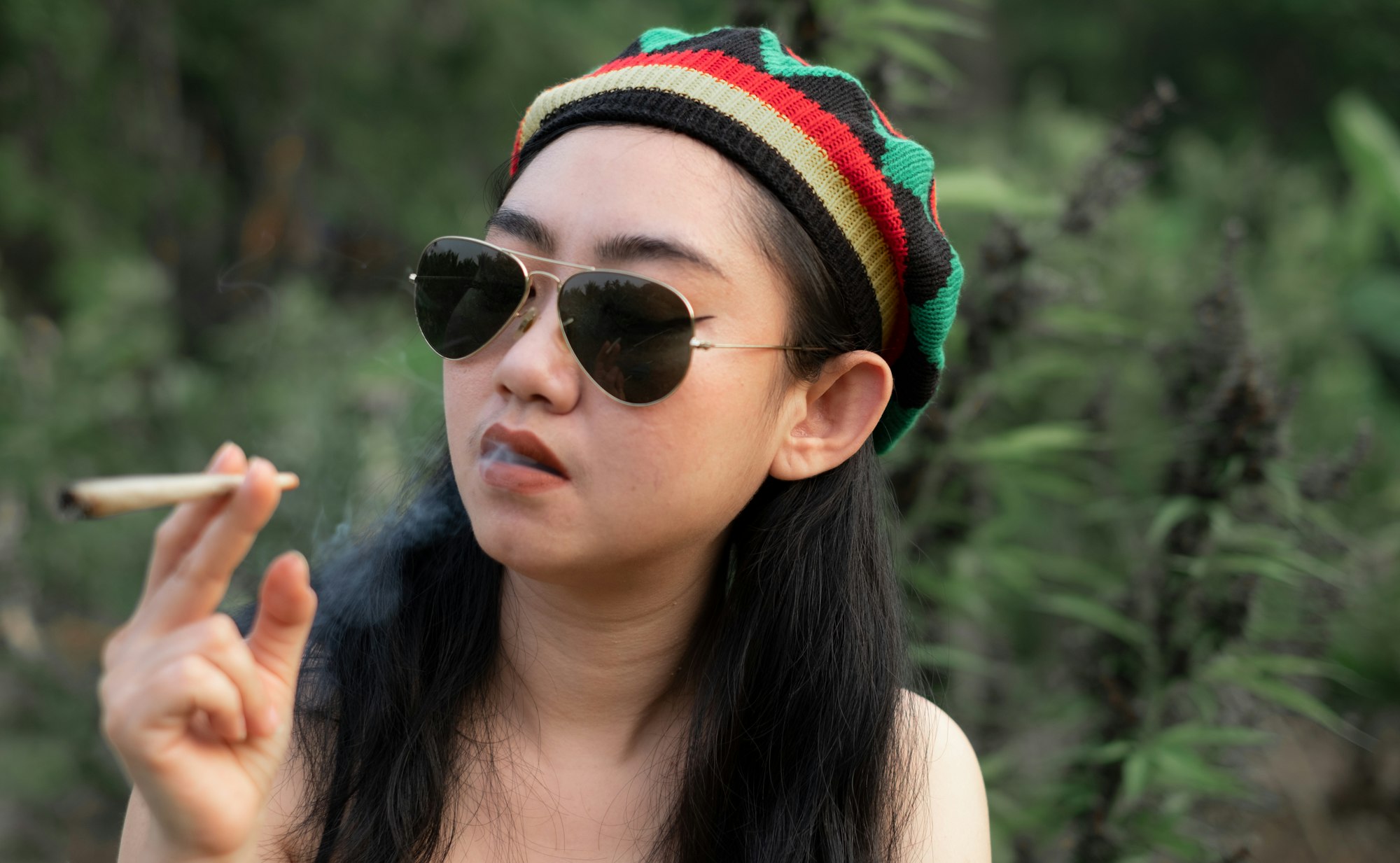 yong asia woman smoking marijuana at cannabis tree plant background 1